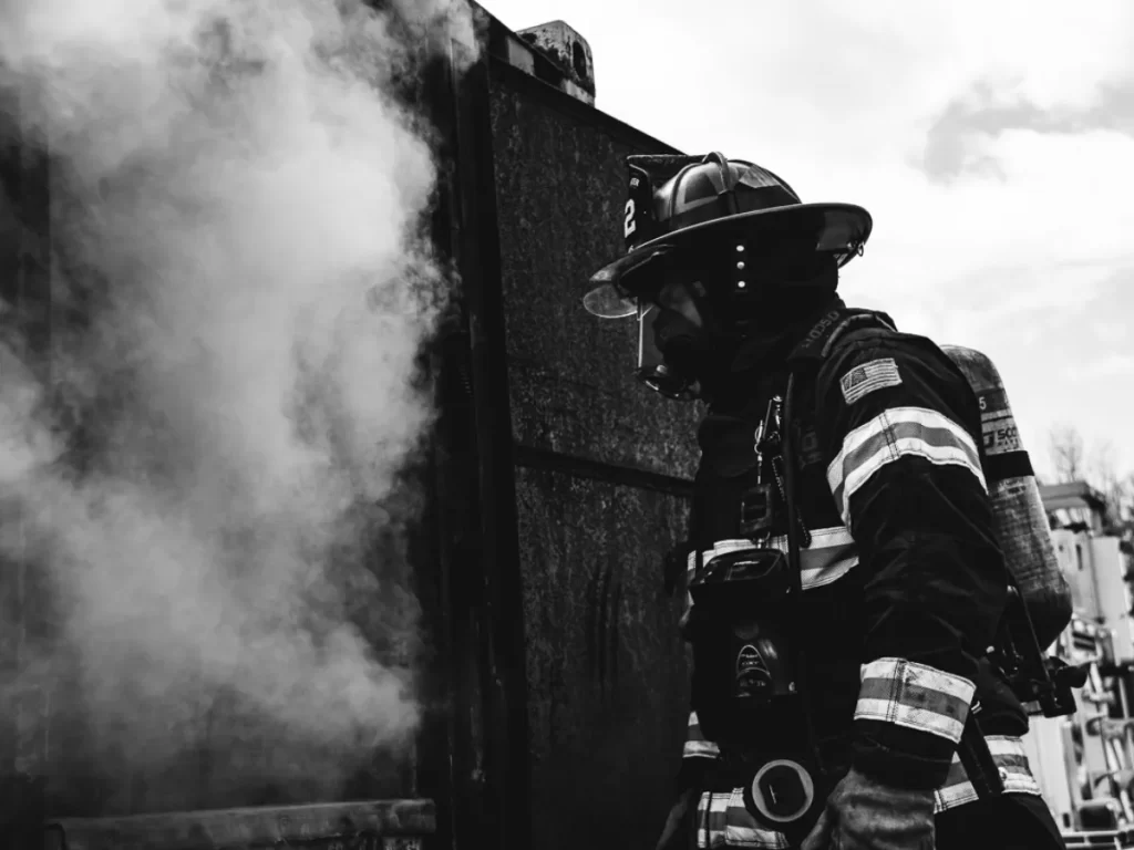 Firefighter wearing an SCBA preparing to enter smoky building