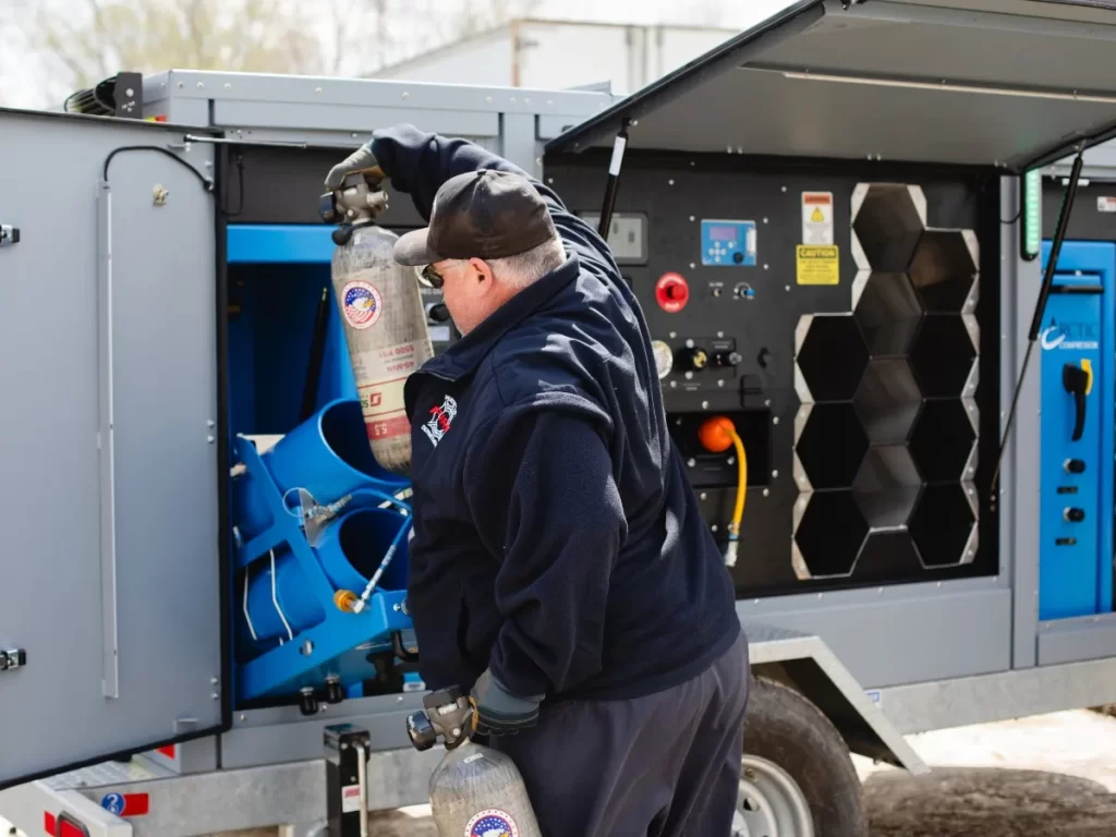 firefighter loading cylinder into Arctic ALL POWER Mobile Air Trailer